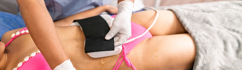 Woman undergoing coolsculpting fat freezing treatment on abdomen for body contouring and stubborn fat reduction